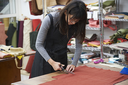 在制作手提包的女缝纫工眼镜女高清图片素材