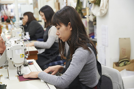 在制作手提包的女缝纫工高兴高清图片素材