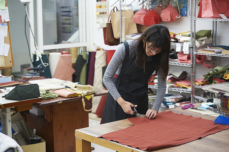 在制作手提包的女缝纫工年轻高清图片素材