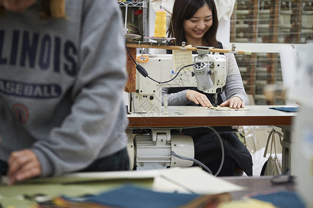 工厂里年轻的缝纫工面料高清图片素材
