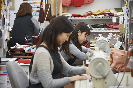 工厂里年轻的缝纫工布料高清图片素材