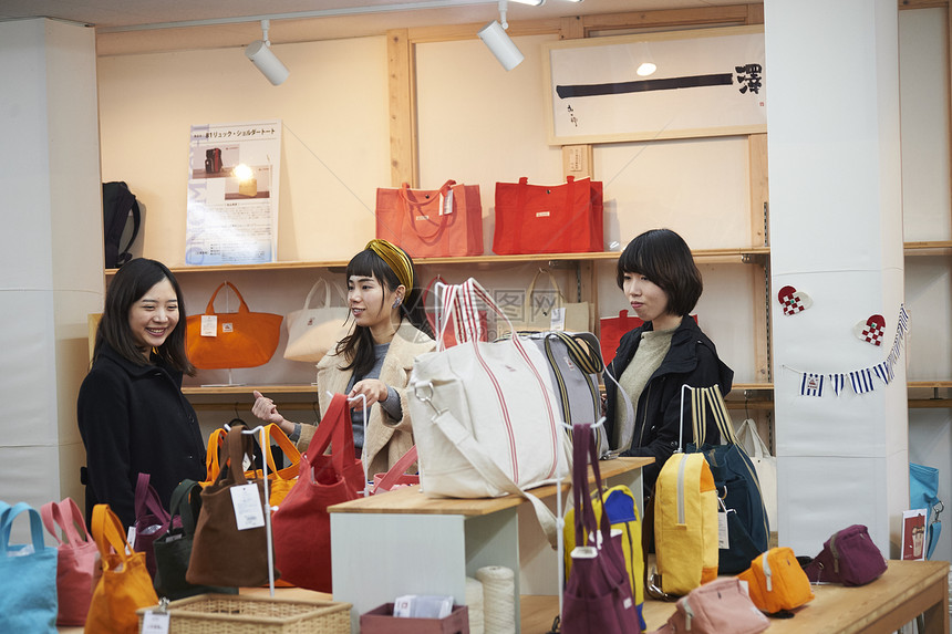 三个女生在手作店里挑选背包图片