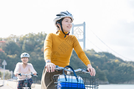 戴着头盔骑自行车的两名女性图片
