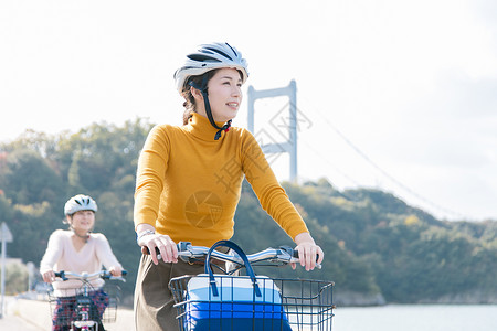 戴着头盔骑自行车的两名女性图片