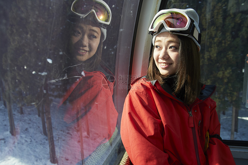 参加俱乐部滑雪活动的女人在缆车上看窗外图片