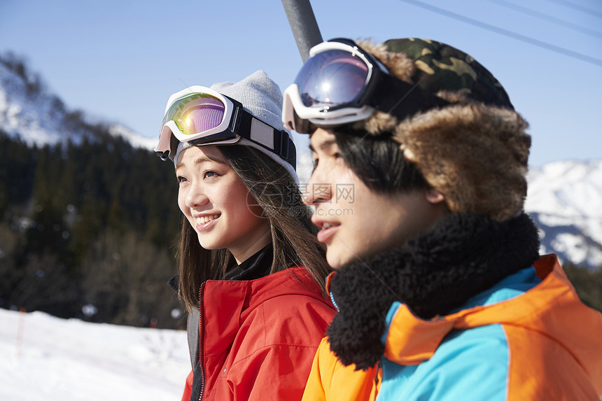 参加俱乐部滑雪活动的情侣在缆车上聊天图片