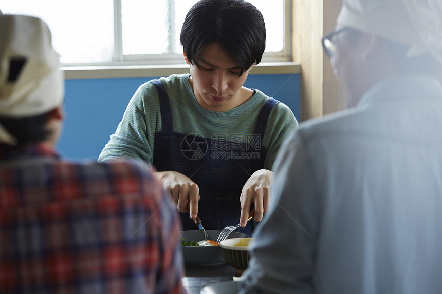 在学习烹饪的烹饪班成员在试吃图片