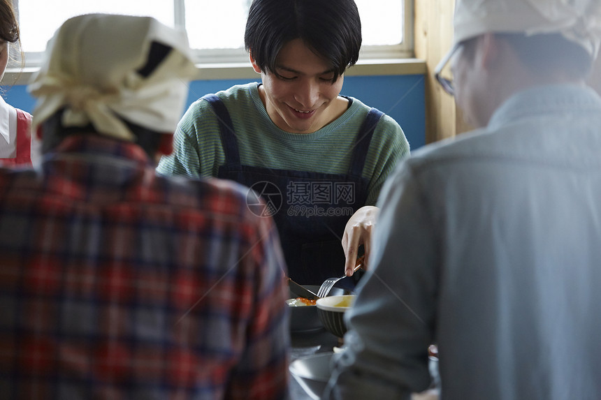 在学习烹饪的烹饪班成员在试吃图片