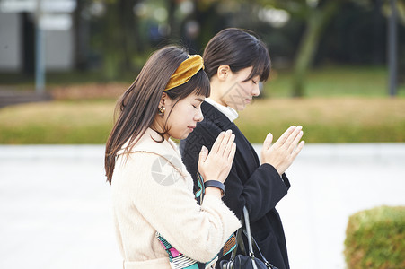 在广岛和平纪念公园祈祷的女人背景图片