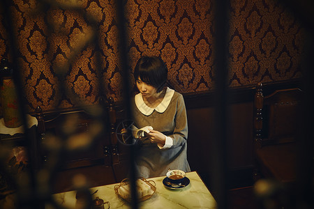 坐在咖啡桌旁喝咖啡的女生图片