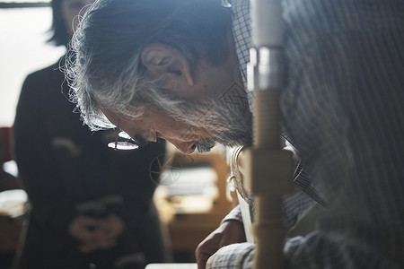 手工艺人在指导学生装订书籍背景图片