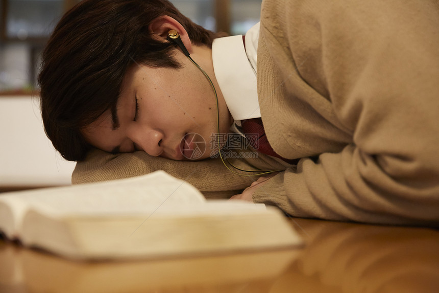 带着耳机看书睡着的男孩图片