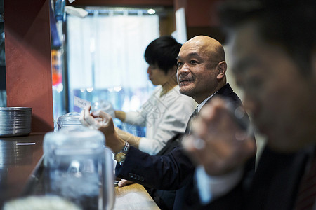 坐着等待食物上桌的男人图片