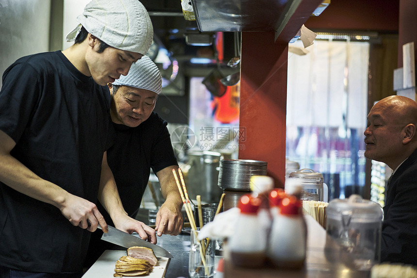 在制作食物的厨师和等待用餐的顾客图片