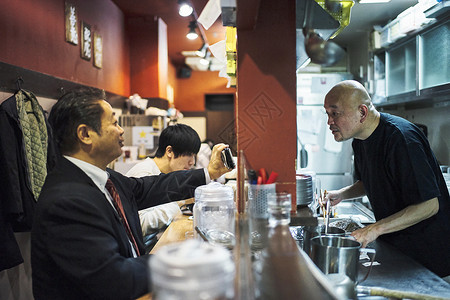 拉面店的厨师和客人背景图片