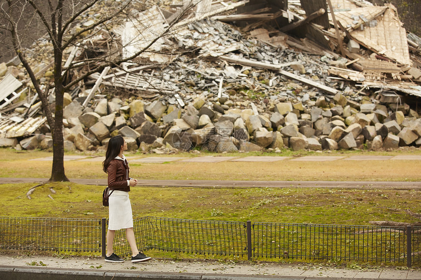 游览户外旅游观察熊本城堡的妇女图片