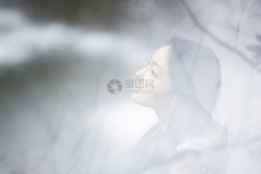 站在雾中的年轻女性图片