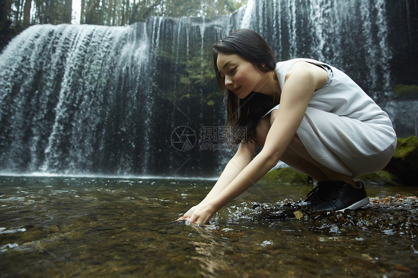 女人在溪边捧起水图片