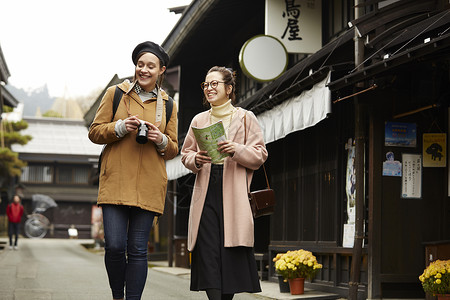 带着相机外国妇女和拿着地图的日本妇女在老街道采风岐阜县背景图片