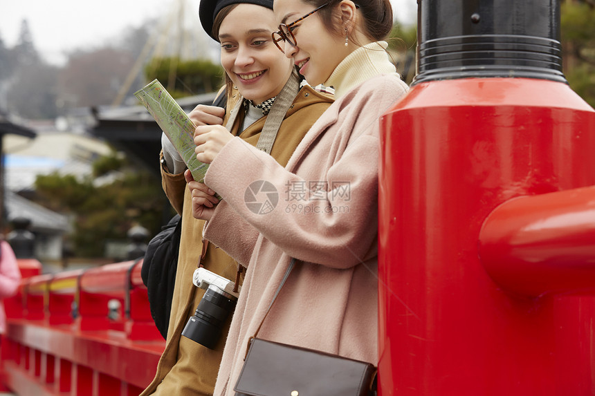 带着相机外国妇女和拿着地图的日本妇女在老街道采风岐阜县图片