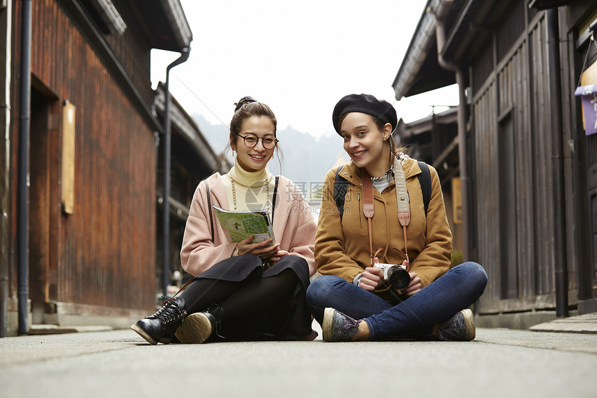 带着相机外国妇女和拿着地图的日本妇女在老街道采风岐阜县图片