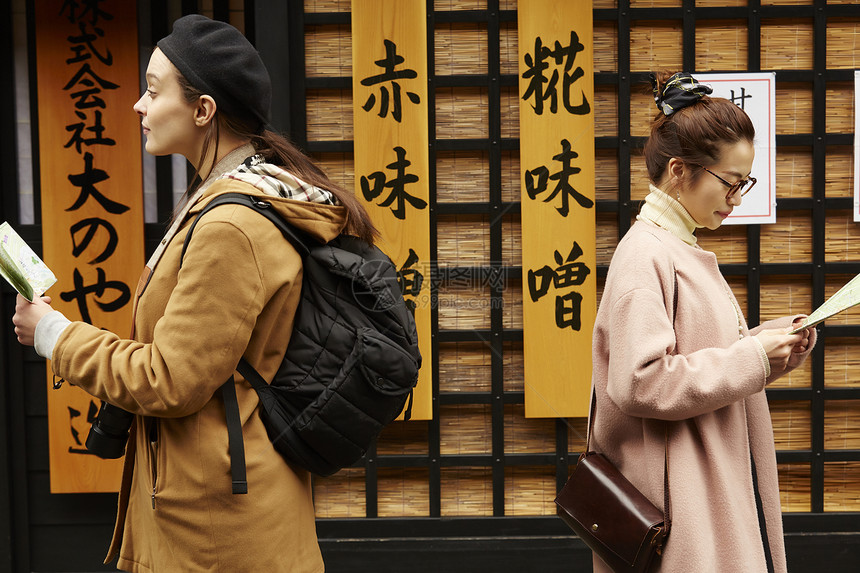 带着相机外国妇女和拿着地图的日本妇女在老街道采风岐阜县图片