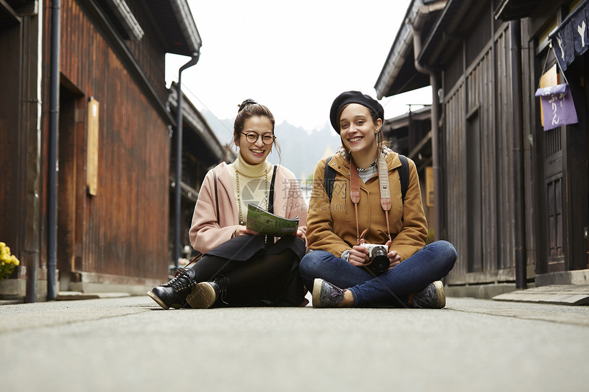 带着相机外国妇女和拿着地图的日本妇女在老街道采风岐阜县图片