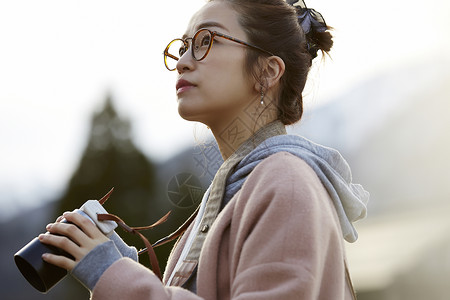 戴眼镜的女人拿着相机来采风背景图片