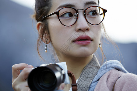 戴眼镜的女人拿着相机来采风背景图片