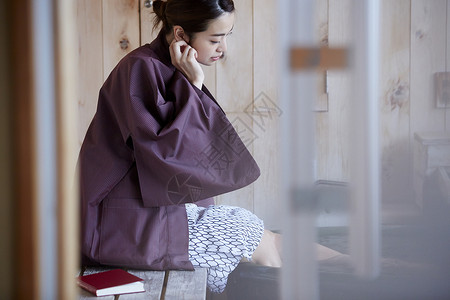 女人换上现代和服坐在室内温泉边图片