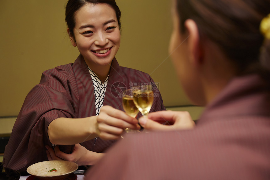 穿着现代和服的两个女人在享受美食图片