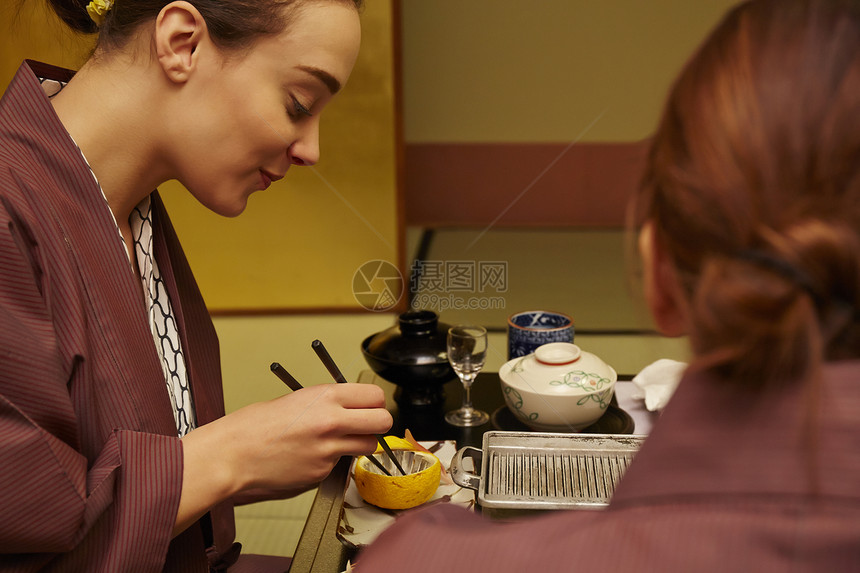 穿着现代和服享受美食的两个女人图片