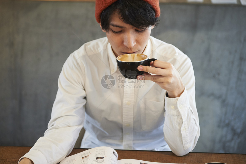 咖啡厅喝咖啡看报纸的男青年图片