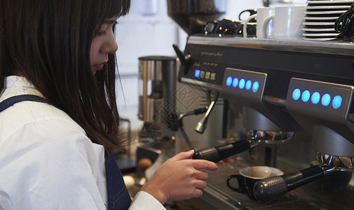 女性咖啡师使用咖啡机冲泡咖啡图片