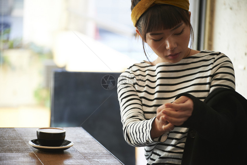 坐二十几岁饮食休息在咖啡馆的妇女图片