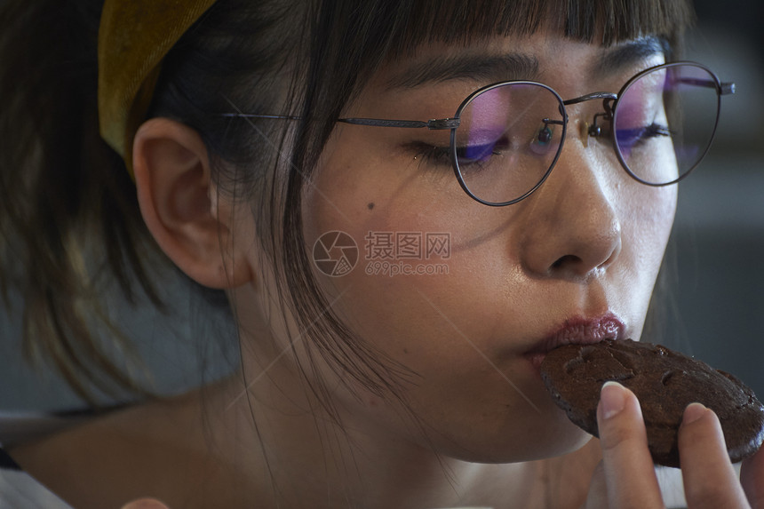 举起日本人咖啡杯放松在咖啡馆的妇女图片