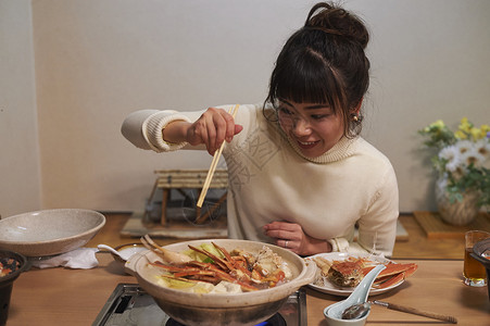 拿着筷子准备吃螃蟹火锅的女性图片