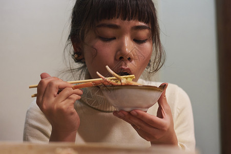 年轻女性开心的吃螃蟹火锅图片