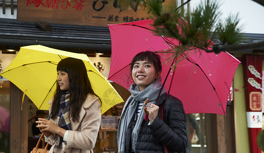二个女孩下雨天游览名胜古迹高清图片