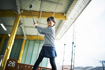 挥舞高尔夫球杆的女孩图片