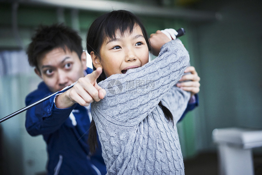 指导女孩学习高尔夫的父亲图片