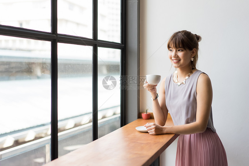坐在窗边喝咖啡的女白领图片