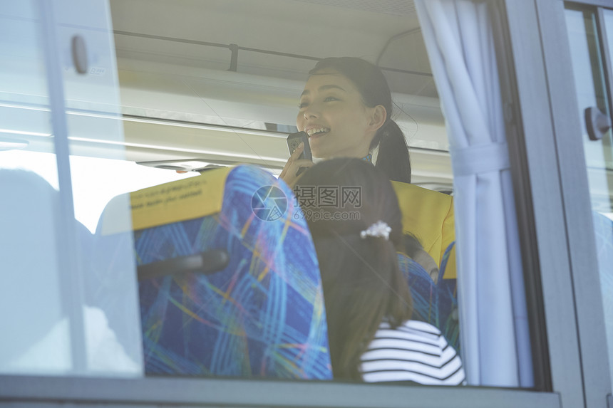 旅游巴士上拿着话筒的年轻导游图片