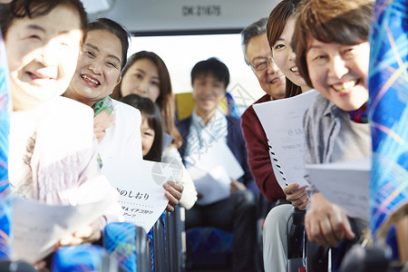旅游巴士上拿着旅游指南开心的乘客图片