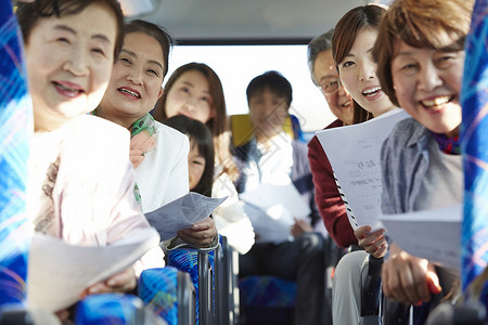 旅游巴士上拿着旅游指南开心的乘客图片