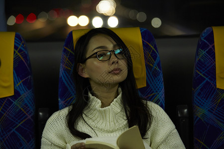 巴士上阅读书籍的年轻女性图片