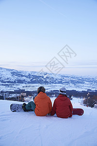  坐在滑雪场上的一对情侣图片
