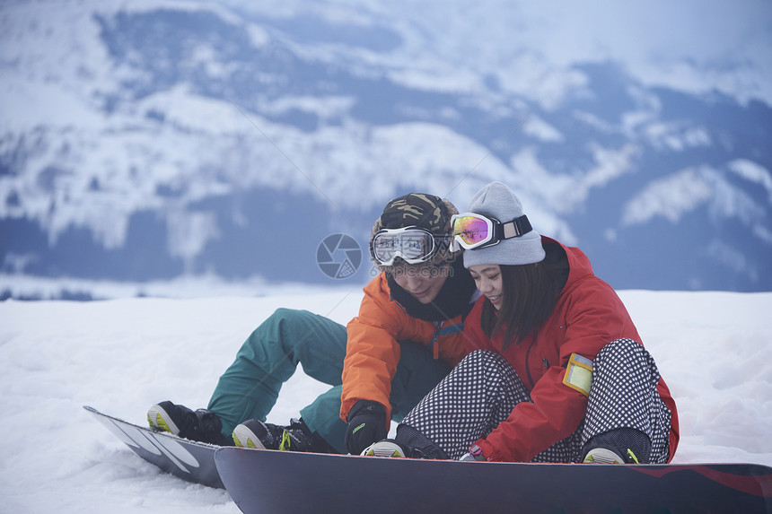 坐在滑雪场休息的一对情侣图片