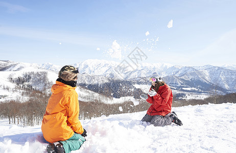  雪地里玩雪的一对情侣图片