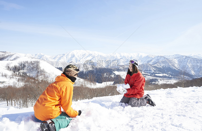  坐在雪地里的一对情侣图片